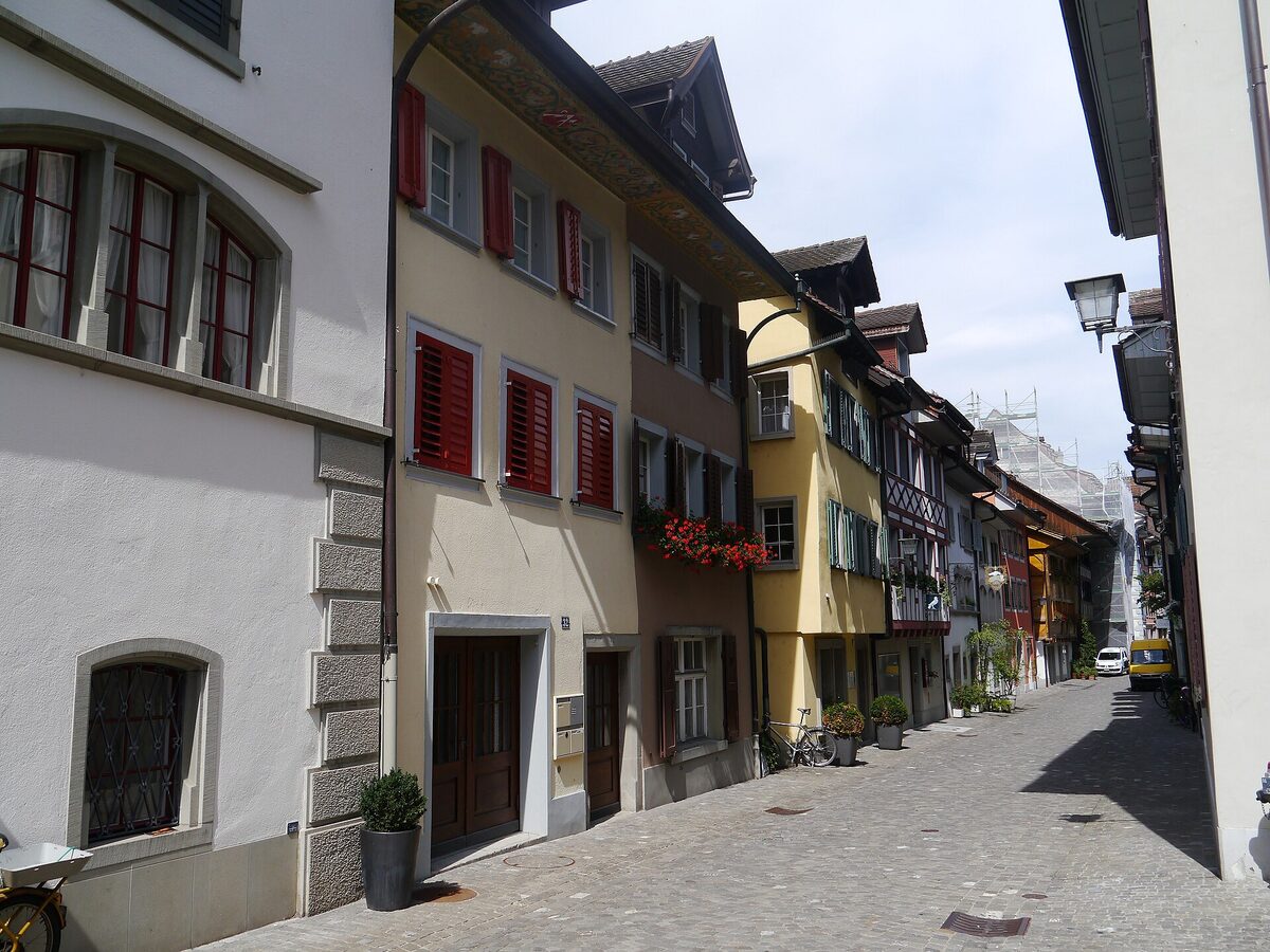 Gasse in der Altstadt von Zug mit roten Fensterläden